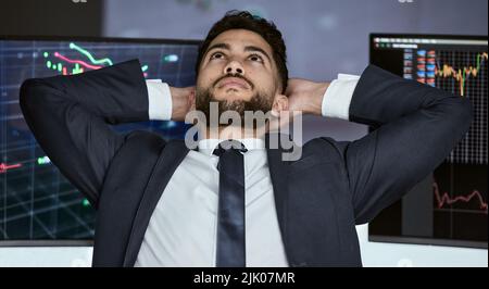 Businessman taking a break from trading on the stock market during a financial crisis. Trader in a bear market thinking, relaxing and making a Stock Photo