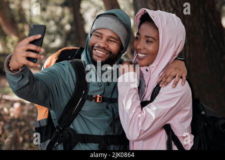 Taking a selfie on our first hike together. a young couple taking a selfie while out on a hike. Stock Photo