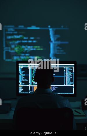 Software developer working in office late at night Stock Photo