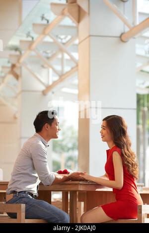 A young Asian couple enjoying a romantic time together outdoors in a ...