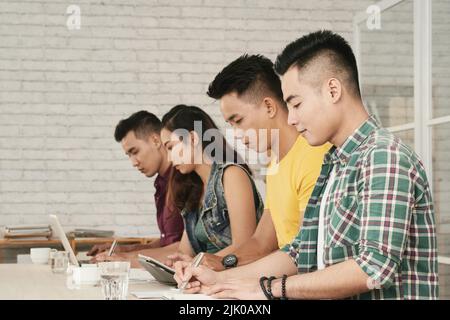 Young Asian business people concentrated on work Stock Photo