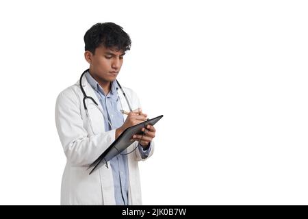 Young peruvian male doctor writing a medical report on a folder, isolated. Stock Photo