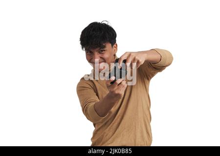 Young peruvian man playing video games with a joystick, isolated. Stock Photo