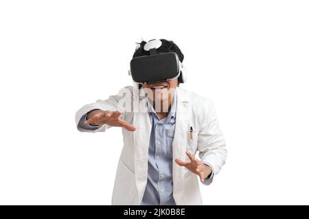 Young peruvian male scientific using virtual reality headset, isolated. Stock Photo