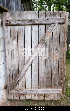Detail of a open wooden door with big wooden lock in an old shack. Stock Photo