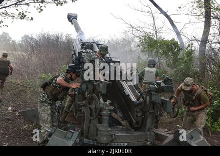 Ukrainian servicemen fire a M777 howitzer towards Russian positions at ...