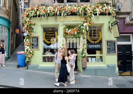 arcade shop covered in fake flowers edinburgh royal mile scotland in summer 2022 UK Stock Photo