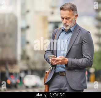 This is an interesting message. a mature businessman using his smartphone to send a text message. Stock Photo