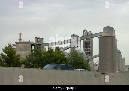 Factory. Cement factory seen from the outside on a cloudy day, in Spain. Europe. Horizontal photography. Stock Photo