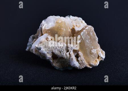 Honey calcite in crystal and needle form. Honey Calcite also known as Golden or Amber Calcite is a calcium carbonate mineral that occurs in masses and Stock Photo
