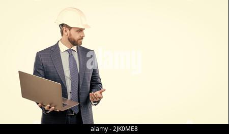 Serious engineer man in hardhat and suit use laptop computer for constructing, engineering Stock Photo