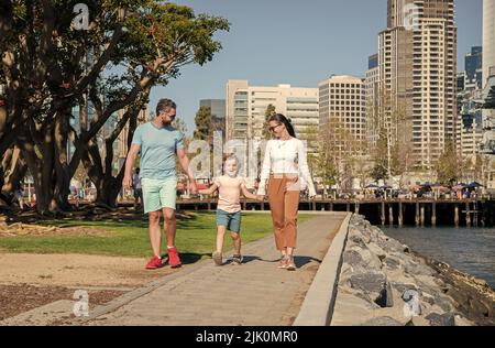 happy young mom and dad walking in park with son, adoption Stock Photo