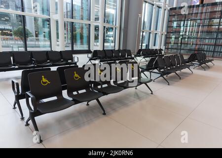 Reserved seats and signs for people with special needs at Istanbul Airport terminal, Turkiye Stock Photo