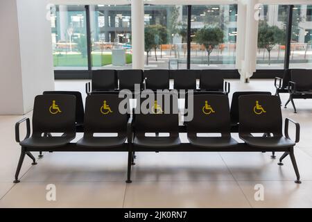 Reserved seats and signs for people with special needs at Istanbul Airport terminal, Turkiye Stock Photo