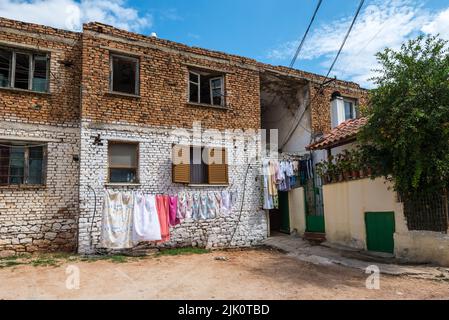 Ksamil, Albania - September 9, 2021: Street view of Ksamil at day with the old house in a poor area. Laundry is dried on a rope outside. Stock Photo