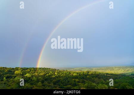 Rainbow in the field after the rain storm in spring. Madrid Stock Photo