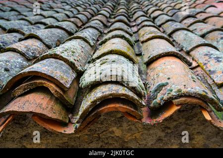 Old medieval house roof made with clay tiles aged by the passage of time. Spain. Stock Photo