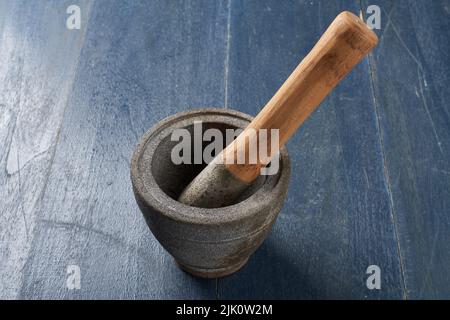 A stone and wood cooking utensil used to grind spices or food ingredients by pounding them Stock Photo