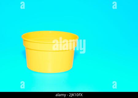Yellow plastic jar capacity of isolated on blue azure Stock Photo