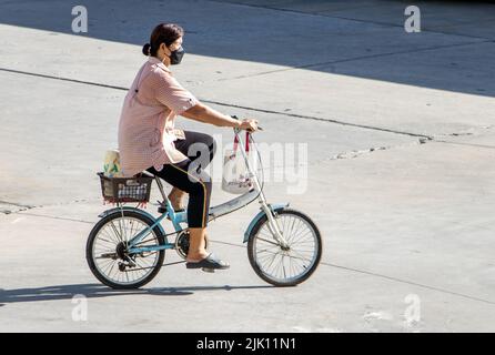 SAMUT PRAKAN, THAILAND, MAY 26 2022, A woman ride on a bicycle at city street. Stock Photo
