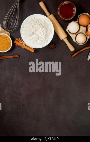 Top view of ingredients bakery making on dark old table. Flour, eggs,  sugar and  cinnamon. Ingredients for making dough, cakes, muffins, pies. Stock Photo