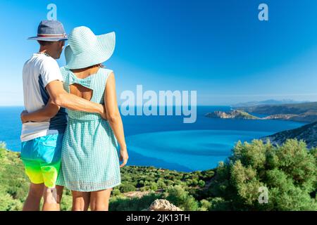 Man and woman in love embracing looking at the crystal sea, Myrtos beach, Kefalonia, Ionian Islands, Greek Islands, Greece, Europe Stock Photo