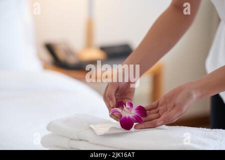 Close-up image of maid putting blooming flower of stack of flowers Stock Photo