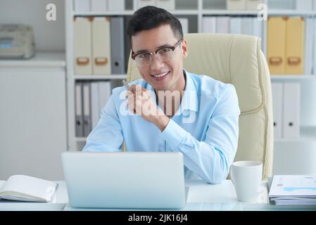 Cheerful Asian businessman working in office Stock Photo