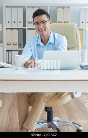 Portrait of young Asian businessman working at his desk Stock Photo