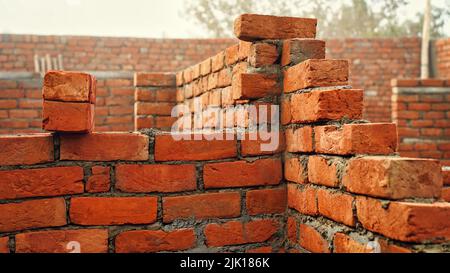 New red brick wall. Red brick wall with contrasty sunlight. building site with scaffolding. India Part of a period house is restored using modern buil Stock Photo