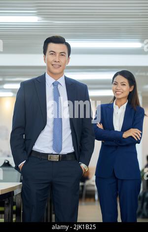 Cheerful Vietnamese business people smiling and looking at camera Stock Photo