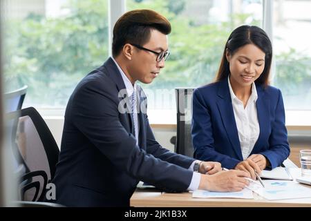 Vietnamese business people checking information in financial documents Stock Photo
