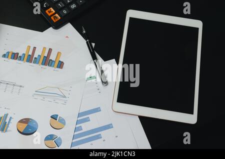 Top view document chart analysis diagram plan financial and graph report information economic and tax with pen and tablet on black desk. Stock Photo