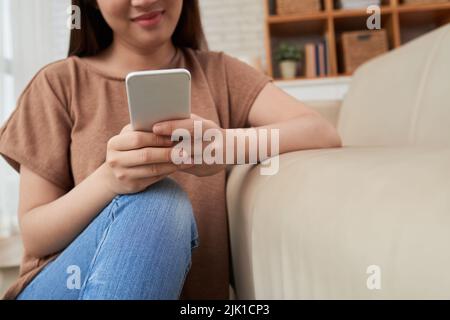 Cropped image of young woman using application on smartphone Stock Photo