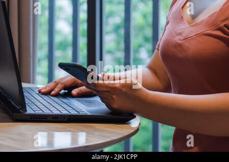 Woman hand holding mobile smartphone digital marketing online technology and communication social network with computer laptop internet browsing and s Stock Photo