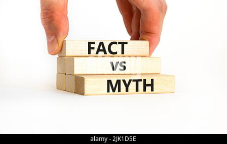 Fact vs myth symbol. Concept words Fact vs myth on wooden blocks on a beautiful white table white background. Businessman hand. Business, finacial and Stock Photo