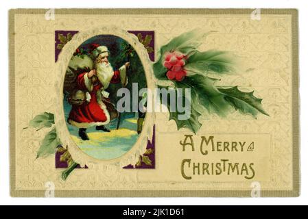 Original Edwardian embossed Christmas card, illustrated with Father Christmas walking through the snow carrying a sack of toys, sprig of holly, wishing  'A Merry Christmas'  U.K. circa 1905, 1910 Stock Photo