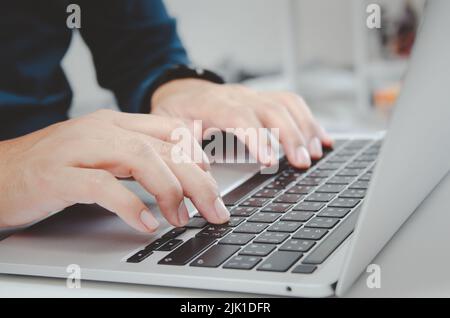 close up hand man typing keyboard computer laptop on desk.Business technology online and communication on desk. Stock Photo