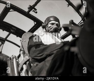The pilot of an Avro Lancaster of No. 103 Squadron RAF based at Elsham Wolds, Lincolnshire, wearing his oxygen mask while flying the aircraft at high altitude. The 'Lancs' first saw service with RAF Bomber Command in 1942 and as the strategic bombing offensive over Europe gathered momentum, it became the main aircraft for the night-time bombing campaigns that followed. Stock Photo