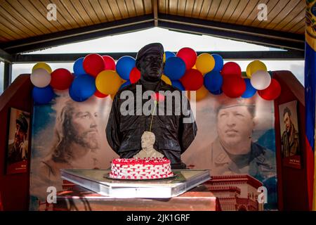 Caracas, Venezuela. 28th July, 2022. A cake stands in front of a statue of the late former president of Venezuela Hugo Chavez on his birthday in front of representations of revolutionary leader Fidel Castro (l-r), Jesus, Hugo Chavez and Ernesto Che Guevara. Credit: Pedro Rances Mattey/dpa/Alamy Live News Stock Photo