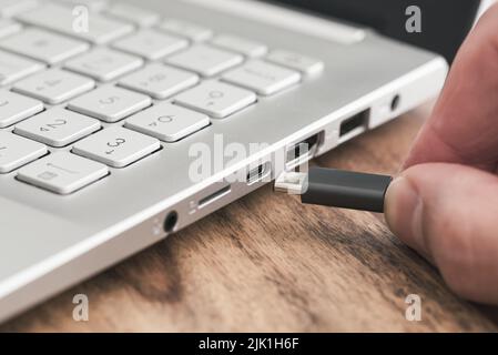 insert USB type c plug into USB port on laptop computer Stock Photo