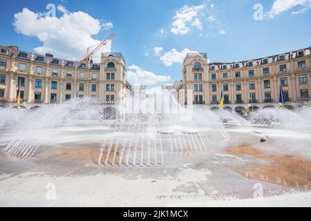 Munich, Germany - July 6, 2022: The Stachus or Karlsplatz in the center of Munich, with its opulent water features. View of the Karlstor through the f Stock Photo
