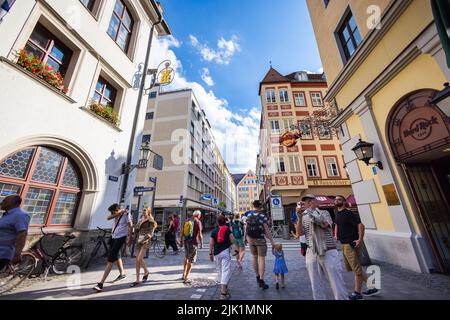 Munich, Germany - July 6, 2022: Street view to the Platzl, alley between Hofbräuhaus and Hard Rock Cafe. Tourists take photos of the famous Beer Hall. Stock Photo