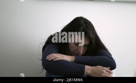 Depressed female person covering face in shame remembering trauma ...