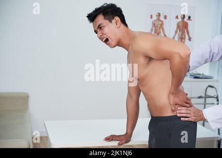 Young man suffering form severe pain in his low back Stock Photo