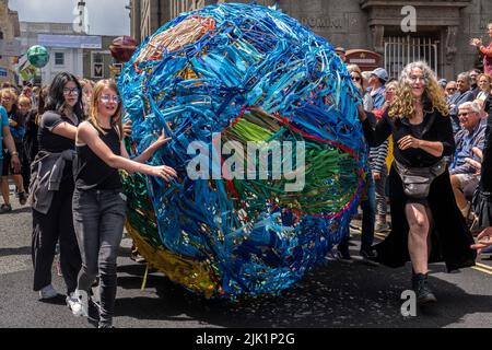 A large model of the Earth made out of strips of coloured colored cloth being rolled along in the Mazey Day parade celebrations as part of the Golowan Stock Photo