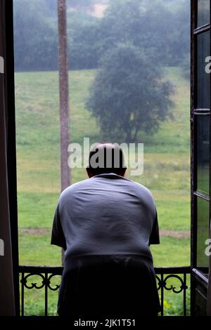 Man looks through the Window, Rain Stock Photo