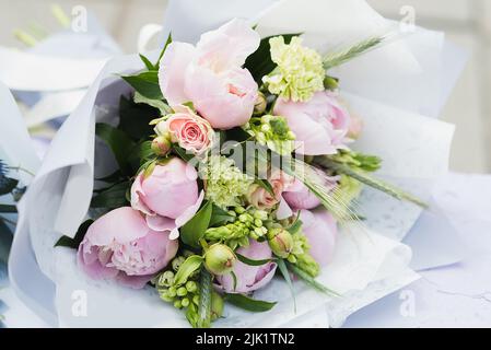 Flower composition with white and pink roses and other flowers. Bridal bouquet with creamy roses and peonies. Farewell Bell. day of knowledge. beginni Stock Photo