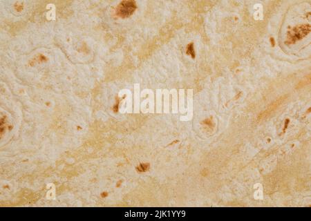 Plain wheat tortilla wraps. Spanish or Mexican circular unleavened flatbread from wheat flour. Ingredient for cooking fast food or snack. Closeup, texture background Stock Photo