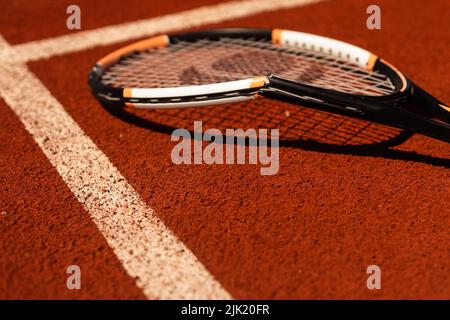 Broken tennis racket on clay tennis court Stock Photo